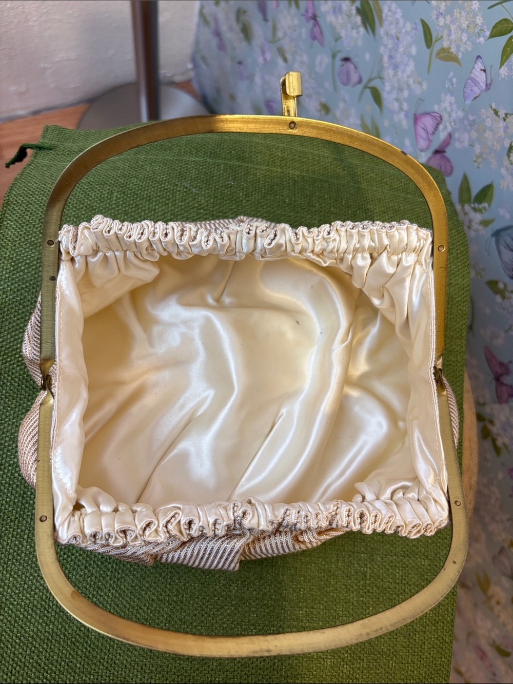 Vintage cream and gold metallic handbag with a brass tone metal frame.